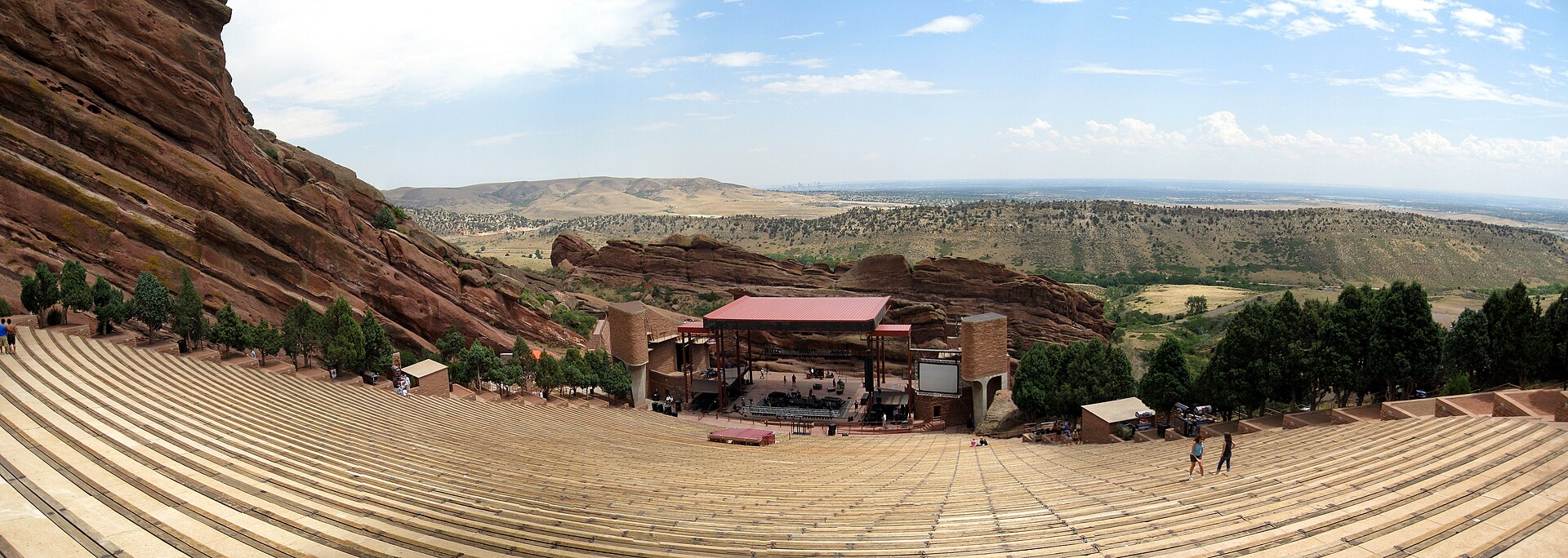 Wide panorama of the Red Rocks stage and amphitheatre seating framed by red sandstone
